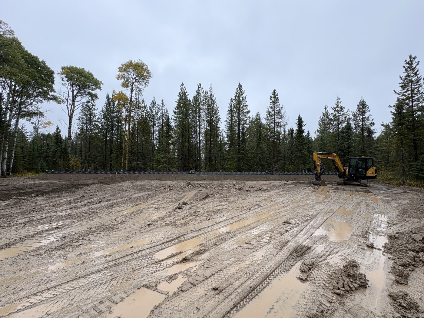 Tim’s yellow tracked excavator on a prepared septic installation site